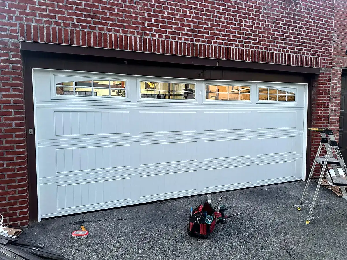 Double-width white carriage door on red brick