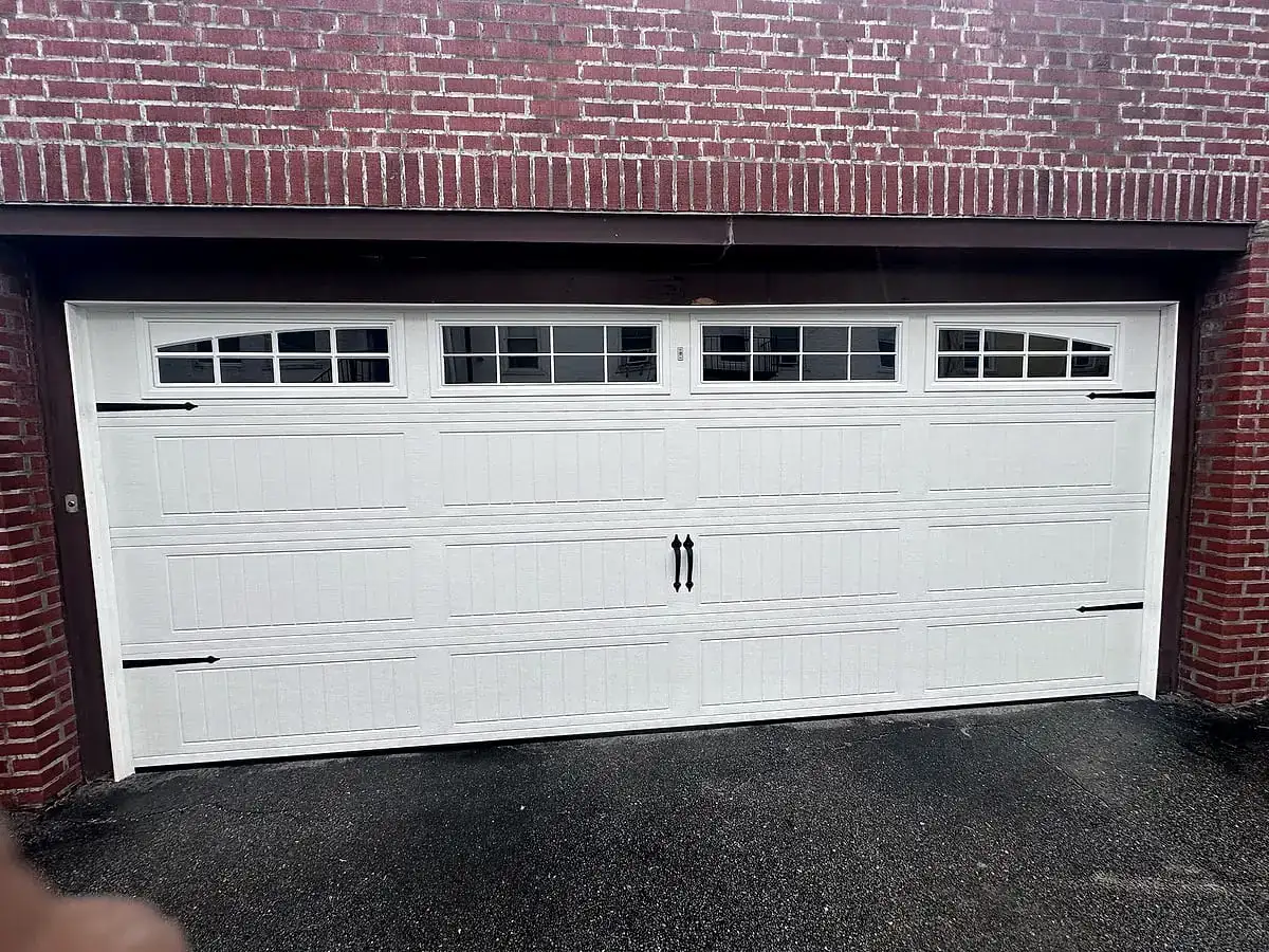 White carriage door with a window row on red brick