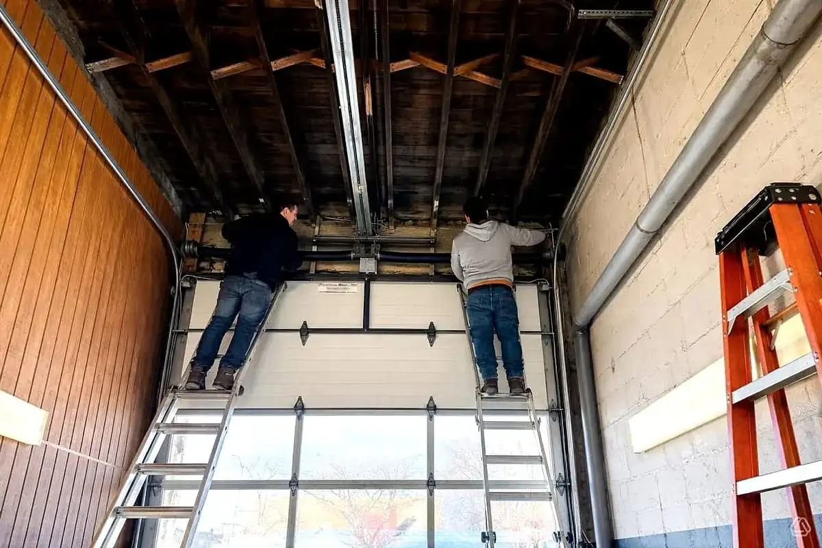 Two technicians hanging tracks on a new install