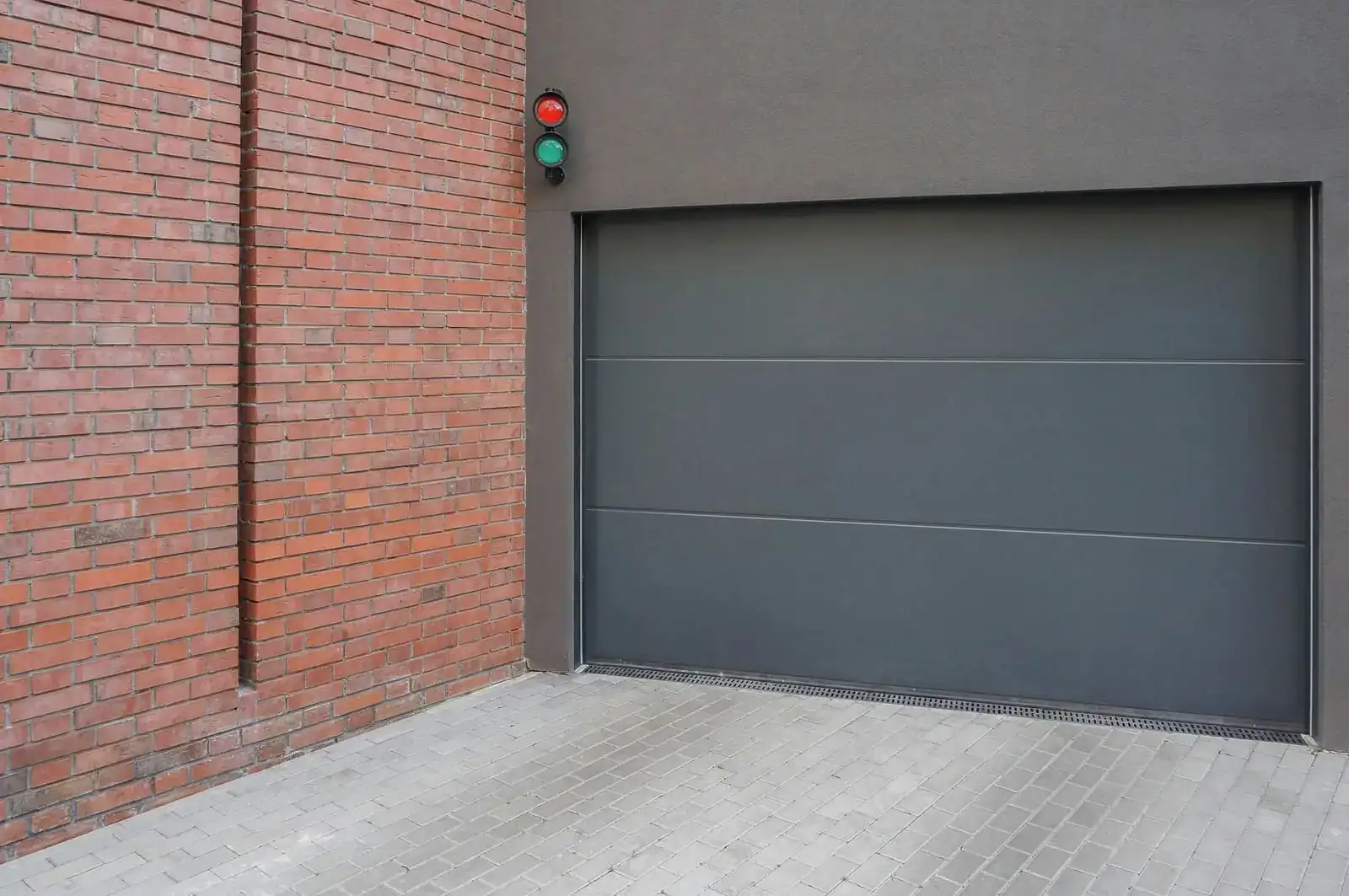 Insulated grey sectional door on brick