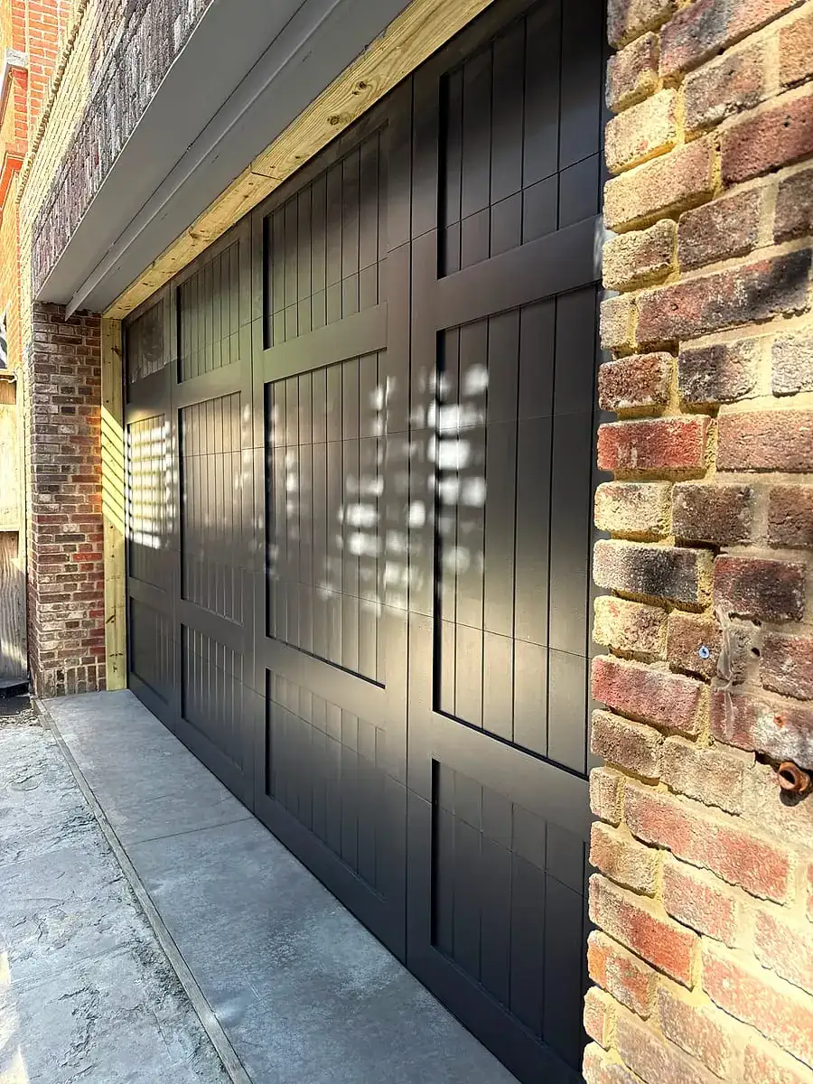 Black carriage-style door set into an old brick opening