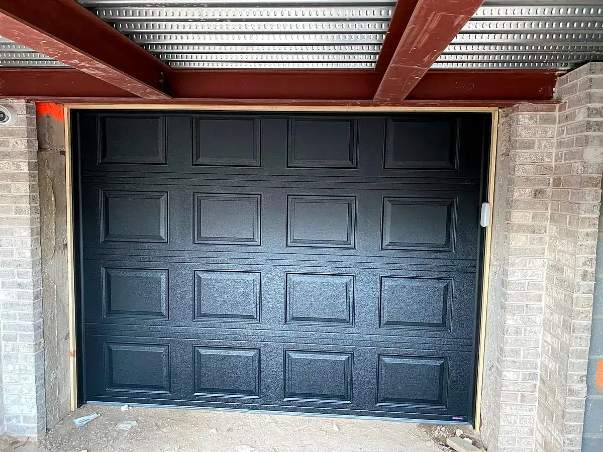 Black raised-panel door with a stone surround