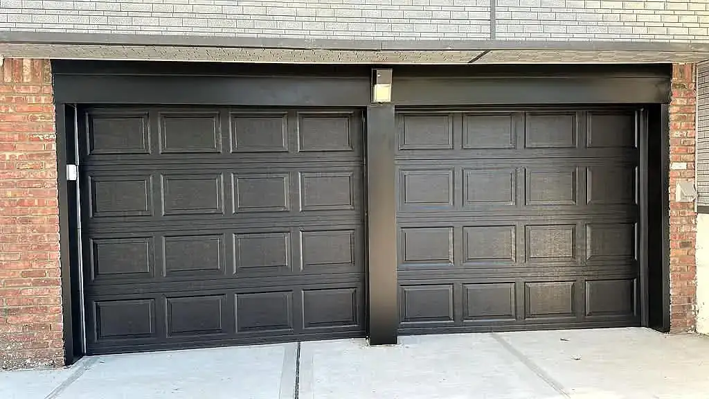 Two black raised-panel doors on brick
