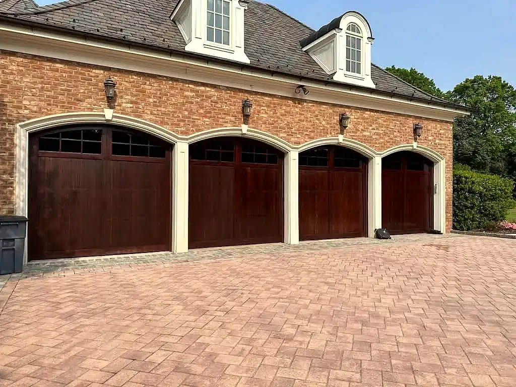 Four stained-wood carriage doors on a brick estate